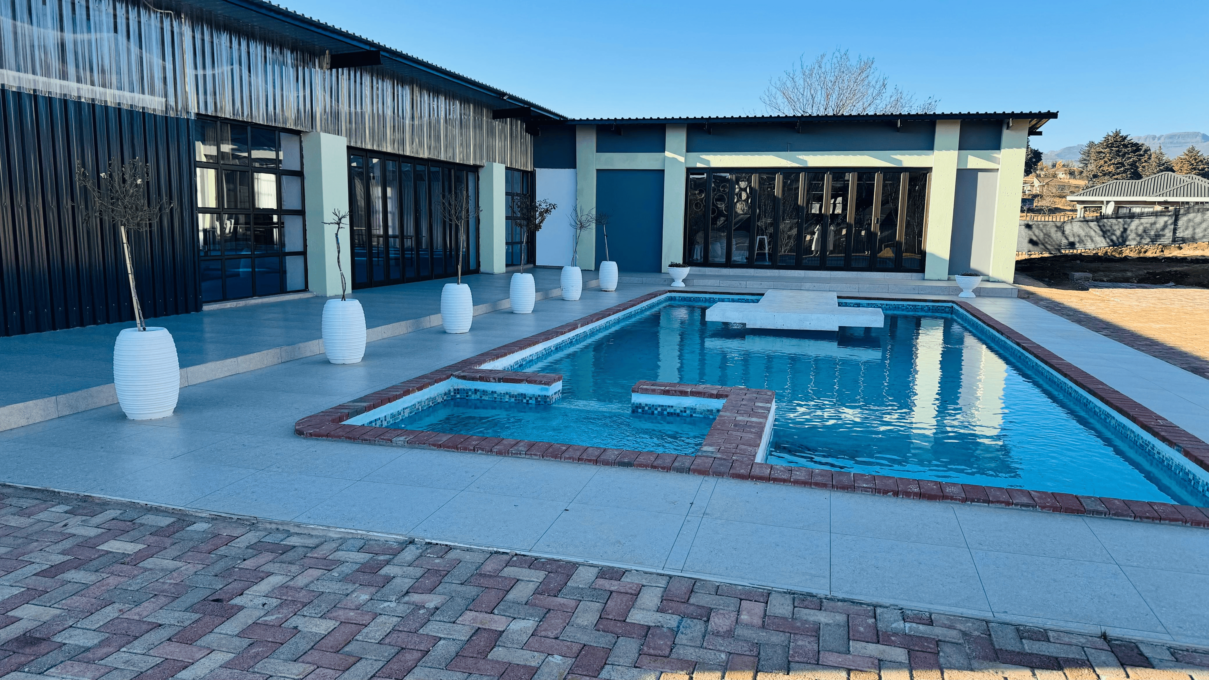 Aloes Lodge exterior at sunset with pool